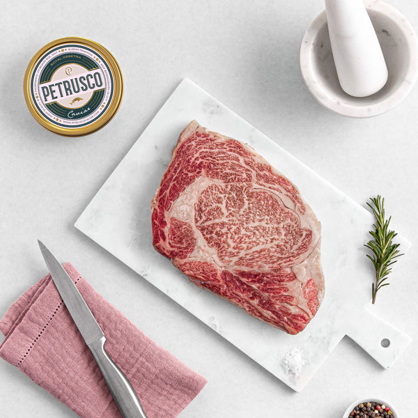 Petrusco Royal Osstera caviar in a tin next to a ribeye