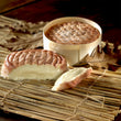 Load image into Gallery viewer, Époisses AOP soft-ripened cheese cut in half showing oozing creamy center, beside its round wooden box on a beige background.
