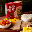 Load image into Gallery viewer, A box of Finn Crisp in front of cheese, tomatoes, and a dip
