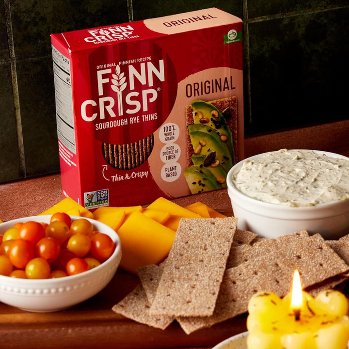 A box of Finn Crisp in front of cheese, tomatoes, and a dip