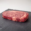 Load image into Gallery viewer, Grass-Fed Australian Wagyu Ribeye MS 8-9 on a dark slate surface with a white background
