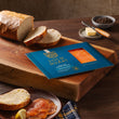 Load image into Gallery viewer, Loch Duart Signature Smoke Salmon package on a wooden cutting board with sliced sourdough bread, butter, and peppercorns.

