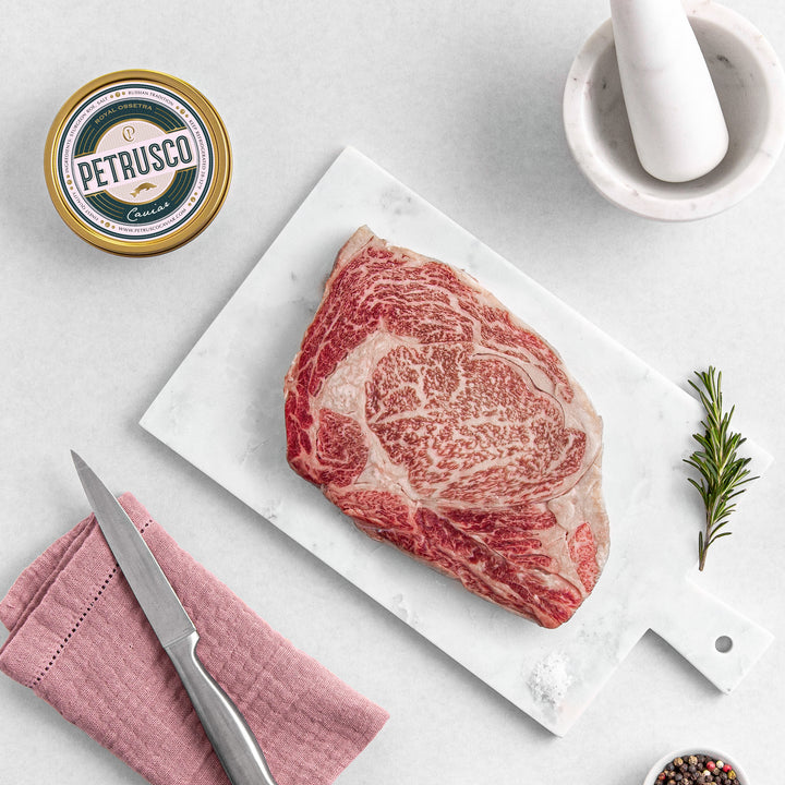 Petrusco Royal Osstera caviar in a tin next to a ribeye