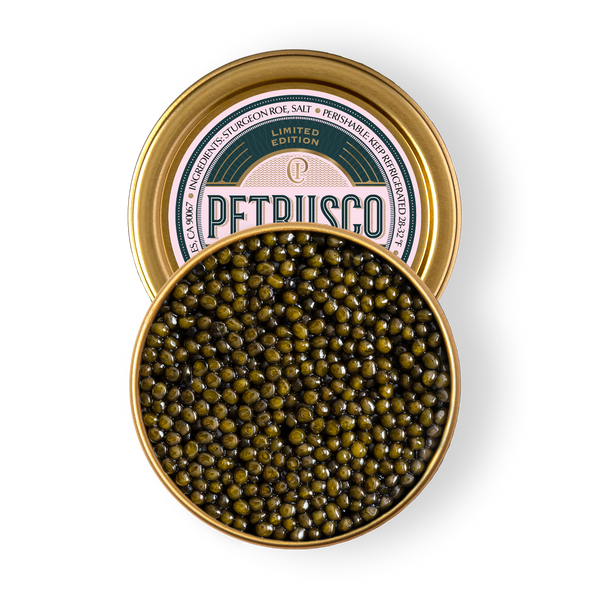 Open tin of Petrusco Limited Edition River Beluga Hybrid caviar showing large, glossy olive-jade pearls on a white background.