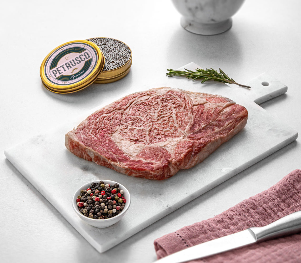 Petrusco caviar in a tin behind peppercorns and a cut of meat