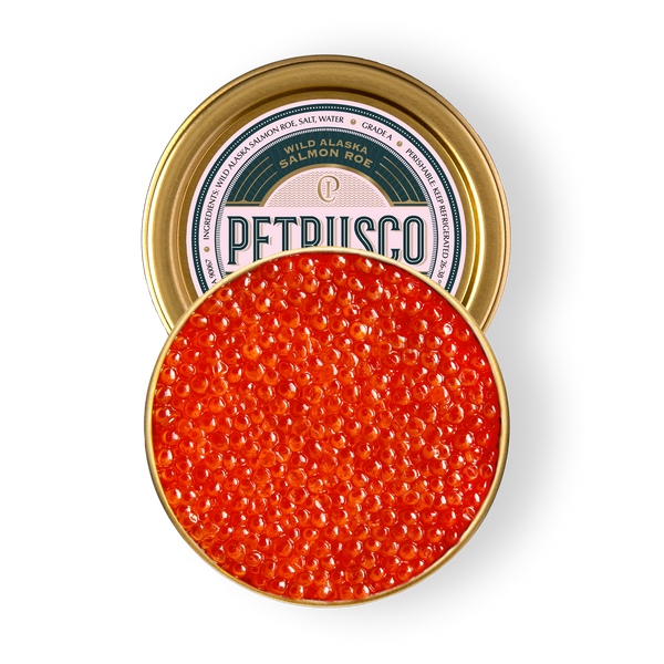 Overhead view of vibrant orange-red wild Alaska salmon roe in an open gold tin.